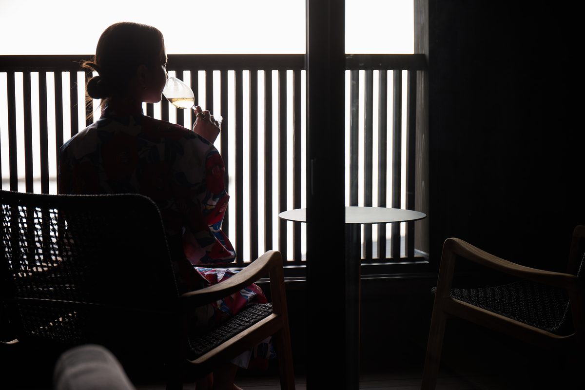 格子窓の前でグラスを傾ける