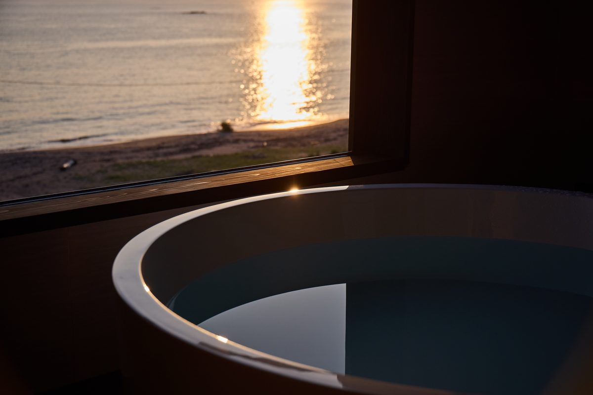 夕陽の海を望む客室の湯船